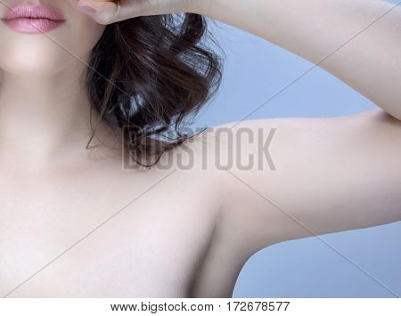 armpit axillary space attractive young caucasian woman  body care isolated  on blue background studio shot figure body applying deodorant