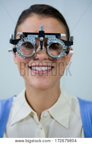 Smiling female patient wearing messbrille during eye examination in in ophthalmology clinic