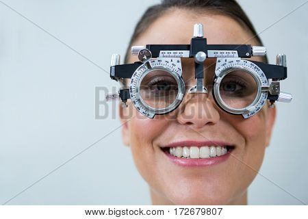 Smiling female patient wearing messbrille during eye examination in in ophthalmology clinic