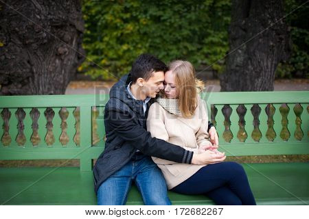 Young Boy And Girl Hugging And Kissing, Sitting On The Bench