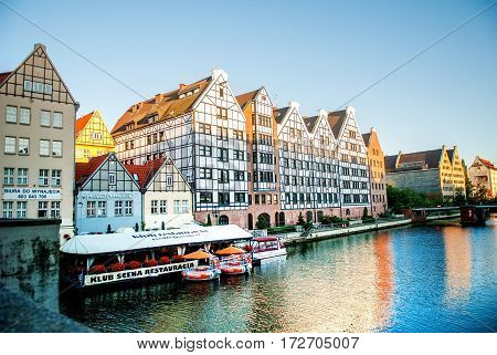 Gdansk Poland - July 18 2014: Old historic granaries on the Granary Island with a restaurant on the water. Embankment of Gdansk is a tourist attraction for visitors.