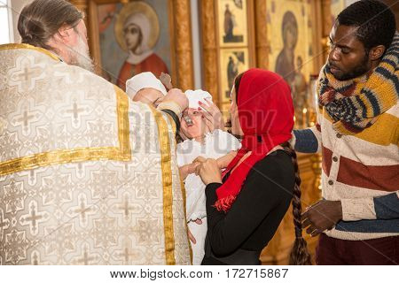 ALMATY KAZAKHSTAN - DECEMBER 17: Christening ceremony on December 17 2013 in Almaty Kazakhstan. Family celebrating baptism in Orthodox Church - Monastery of St. Matrona