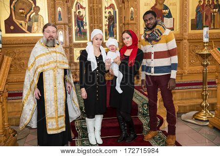 ALMATY KAZAKHSTAN - DECEMBER 17: Christening ceremony on December 17 2013 in Almaty Kazakhstan. Family celebrating baptism in Orthodox Church - Monastery of St. Matrona