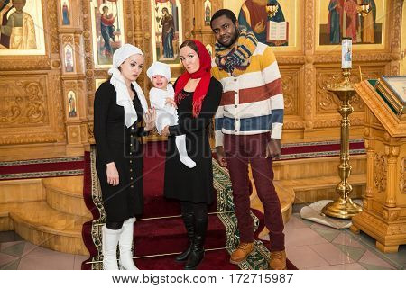 ALMATY KAZAKHSTAN - DECEMBER 17: Christening ceremony on December 17 2013 in Almaty Kazakhstan. Family celebrating baptism in Orthodox Church - Monastery of St. Matrona