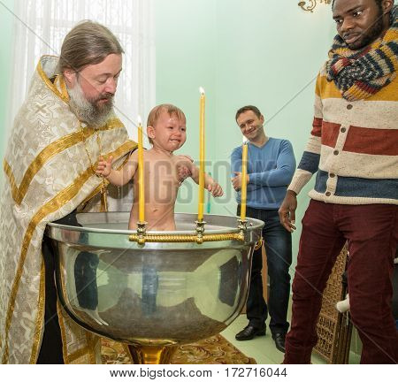 ALMATY KAZAKHSTAN - DECEMBER 17: Christening ceremony on December 17 2013 in Almaty Kazakhstan. Family celebrating baptism in Orthodox Church - Monastery of St. Matrona
