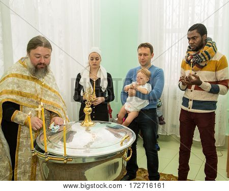 ALMATY KAZAKHSTAN - DECEMBER 17: Christening ceremony on December 17 2013 in Almaty Kazakhstan. Family celebrating baptism in Orthodox Church - Monastery of St. Matrona