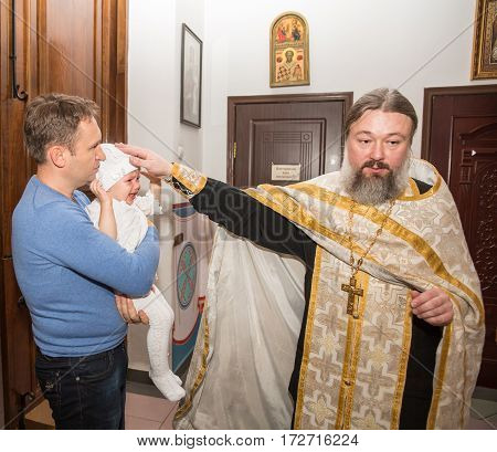 ALMATY KAZAKHSTAN - DECEMBER 17: Christening ceremony on December 17 2013 in Almaty Kazakhstan. Family celebrating baptism in Orthodox Church - Monastery of St. Matrona