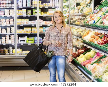 Woman Carrying Shopping Bag In Vegetable Department At Supermark