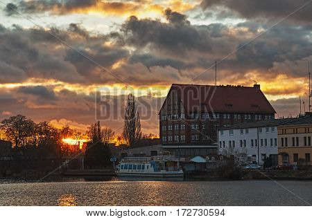 A fiery sunset over the river in the city.