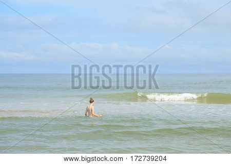 Lonely girl is swims in the sea waves in Vietnam
