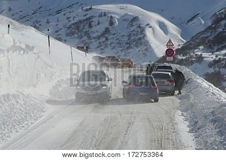 BRIANCON, FRANCE - FEBRUARY 1, 2015 : Cars in a blizzard on an mountain pass. Severe winter weather causes difficulties on the roads.