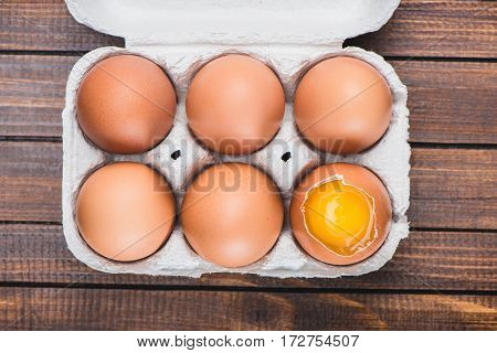 Top view of raw chicken eggs in open carton box on table