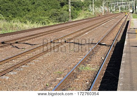 Twin Rail Tracks Leading Through Rural Railway Station