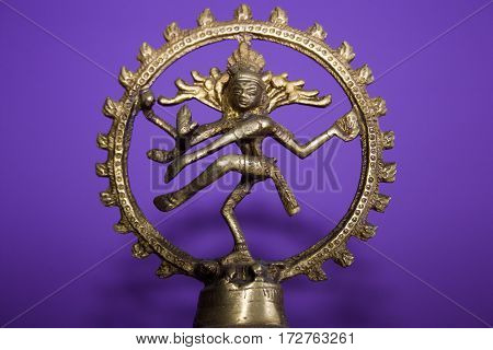 bronze statuette of Shiva Nataraja on a purple background