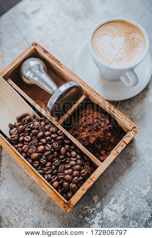 Coffee beans tamper and a cup of delicious coffee