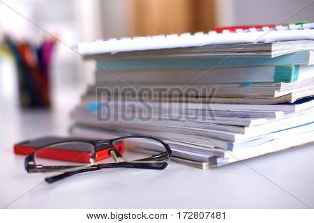 Group of multicolored office folders and glasses.