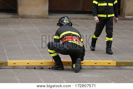 Firemen During Rescue Operations With A Wooden Ladder