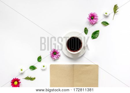 Froral flat lay with cup of coffee and craft notepaper on white background top view mockup