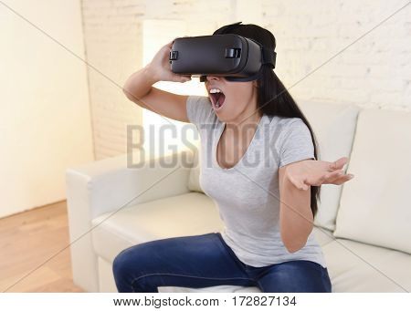 young attractive happy woman at home living room sofa couch excited using 3d goggles watching 360 virtual reality vision enjoying the fun cyber experience in vr simulation reality concept