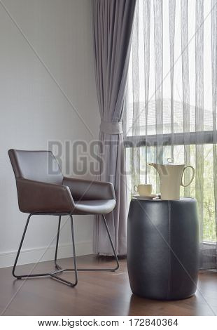 Dark Brown Chair At The Corner With Ceramic Coffee Set On The Table