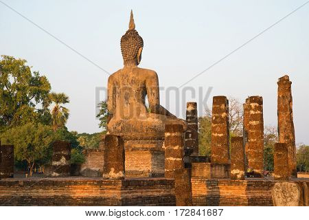 Ancient sculpture of a seated Buddha on the ruins of the temple Wat Chana Songkhram. The view from the back. Sukhothai, Thailand
