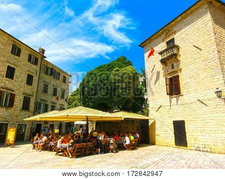 Kotor, Montenegro - May 07, 2014: People sittiing at cafe on St. Luke's square surrounded by traditional stone houses at Kotor's Old Town, Montenegro on May 07, 2014. People walking