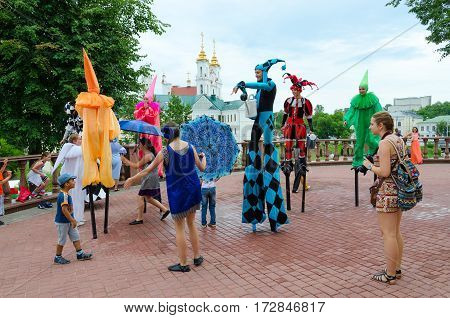 VITEBSK BELARUS - JULY 13 2016: Buffoons on stilts near puppet theater during festival Slavic Bazaar Vitebsk Belarus