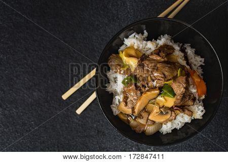 Chinese rice with beef meat and vegetagles on dark background