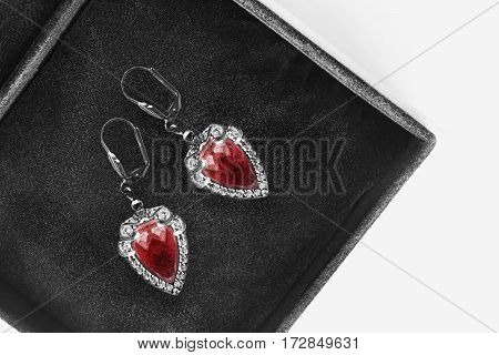 Ruby and diamonds earrings in black jewel box closeup
