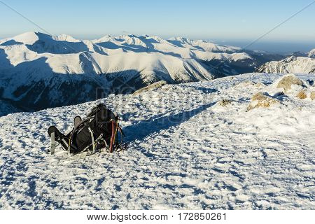 Backpack, Ice Axes And Trekking Poles On A Background Of Mountains