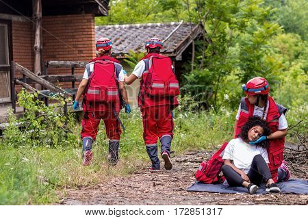 Rescue team helping injured female victim, color image