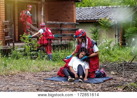 Rescue team helping injured female victim, color image