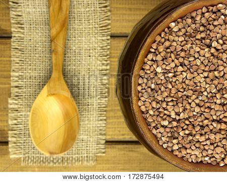 Buckwheat groats in a bowl and wooden spoon
