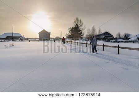 Two skiers skiing on the snow-covered yard. Village Visim, Sverdlovsk region, Russia