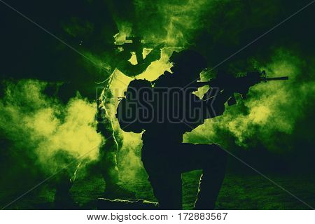 Pair of army soldiers attacking in the smoke. Backlit silhouette, toned image. Army storm concept