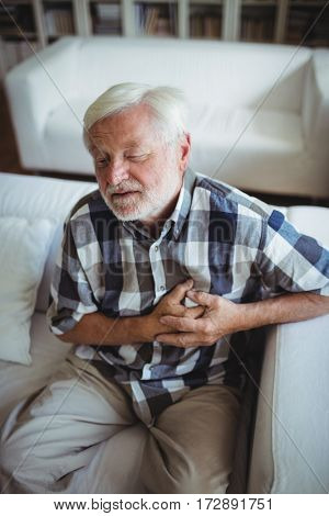 Senior man suffering from chest pain at home