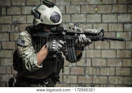 US Army Ranger aiming rifle with two hands. Shooting stance and grip