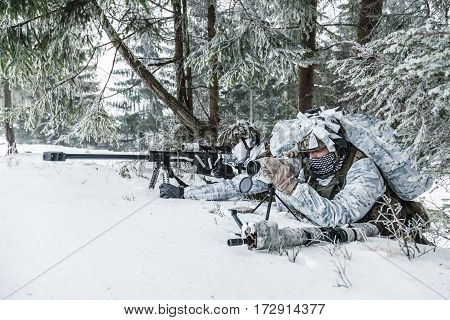 Winter arctic mountains warfare. Action in cold conditions. Sniper and spotter with weapons in wait somewhere above the Arctic circle