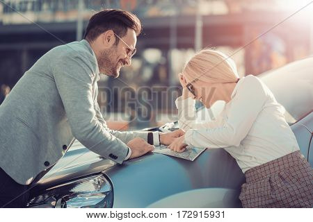 Smiling man and woman using map on roadtrip.Leisureroad trip travel and people concept.