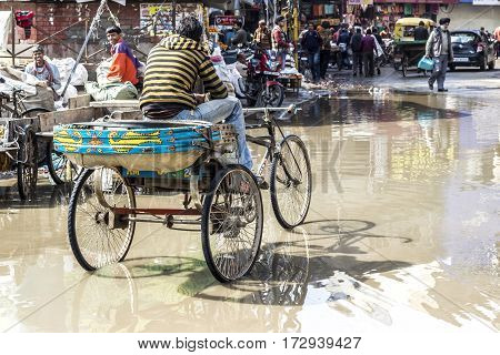 Young Rickshaw Driver Waits For Guests At The Flooded Street In Rainy Season