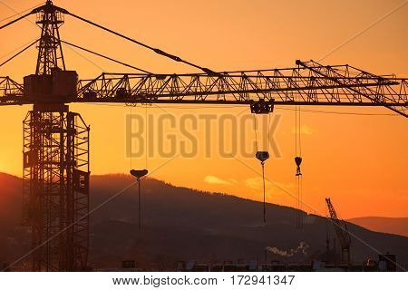 Construction of the building. Construction crane on the sunset background