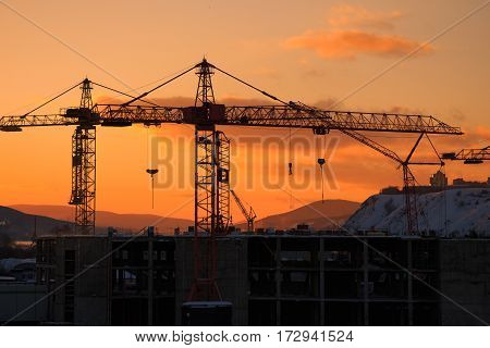 Construction of the building. Construction crane on the sunset background