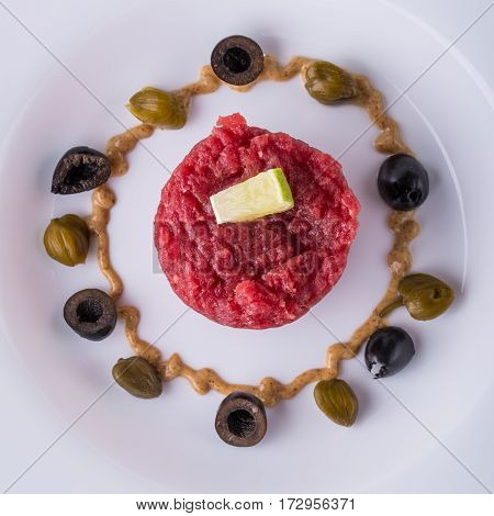 Top View On Single Portion Of Tartar Steak On White Plate