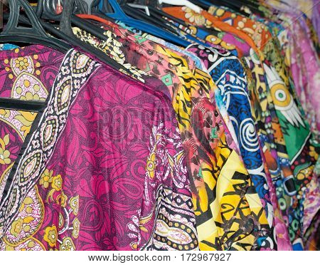 Women's multi-colored Oriental dresses on the market are hung on hangers