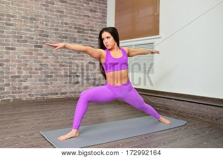 Young woman with beautifull body and long black hair training flexibility in yoga class. Fitness and lifestyle concept