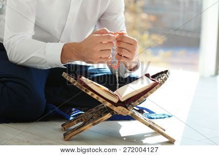 Muslim Man With Koran And Misbaha Praying Indoors, Closeup