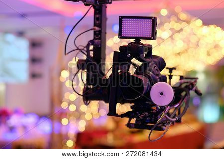 Video Camera On The Crane Conducts Shooting Of A Wedding In The Hall Of Celebrations Against The Bac