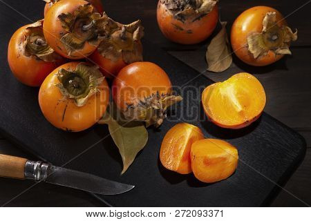 Persimmon Still Life In A Low Key. Organic Kaki Fruit Harvested In Autumn. Diospyros Kaki