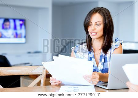 Woman with papers in their living room