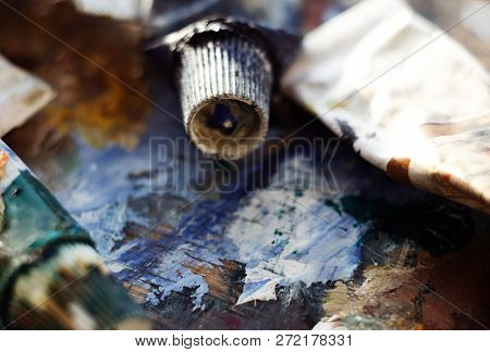 Tubes With Oil Paint Of Different Colors Randomly Scattered On The Palette